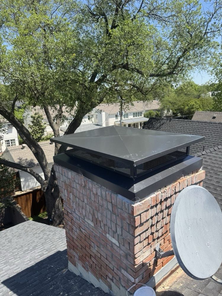 New black powder-coated chimney cap installed on a brick chimney in Dallas–Fort Worth