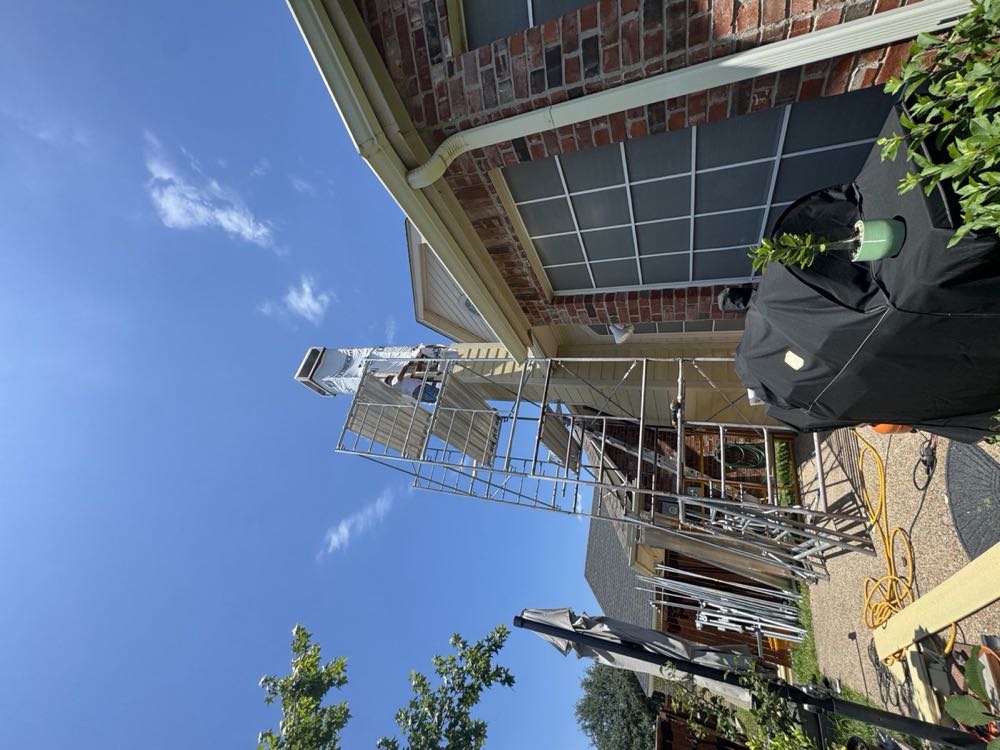 Texan Flue mason repairing spalled chimney brick from scaffolding in North Texas