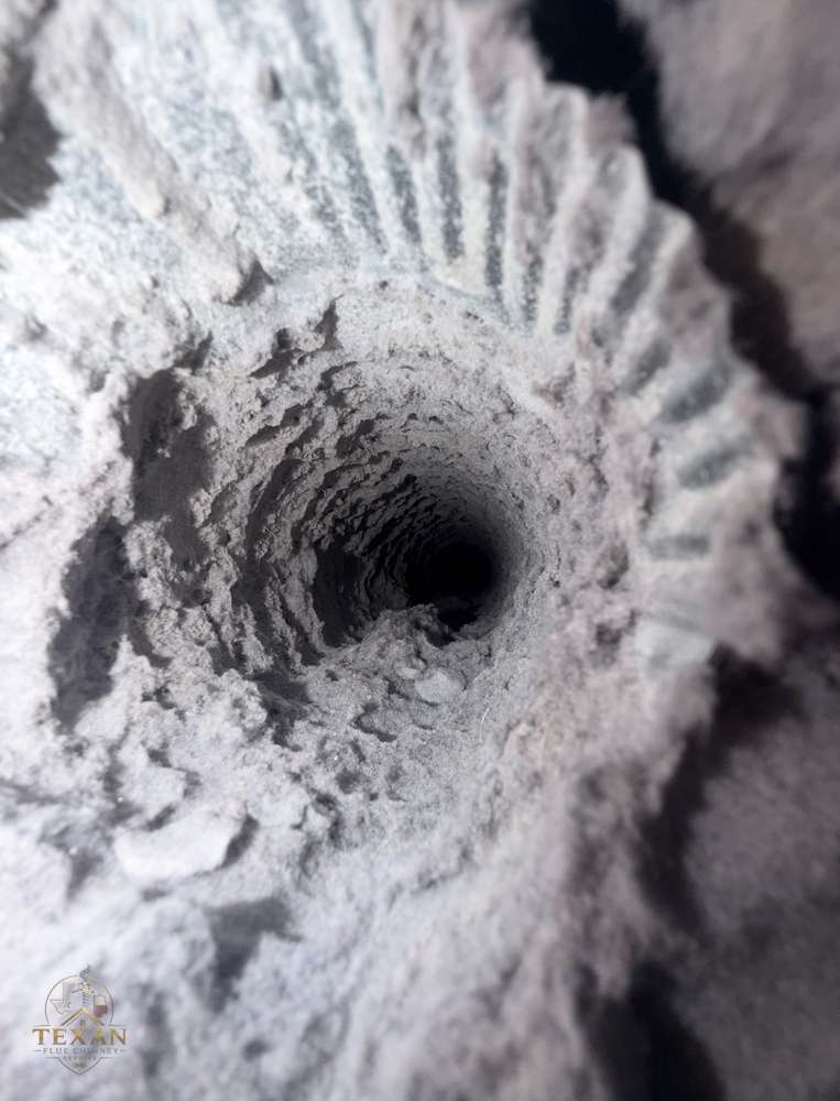 Texan Flue technician clearing a clogged dryer vent in Dallas–Fort Worth
