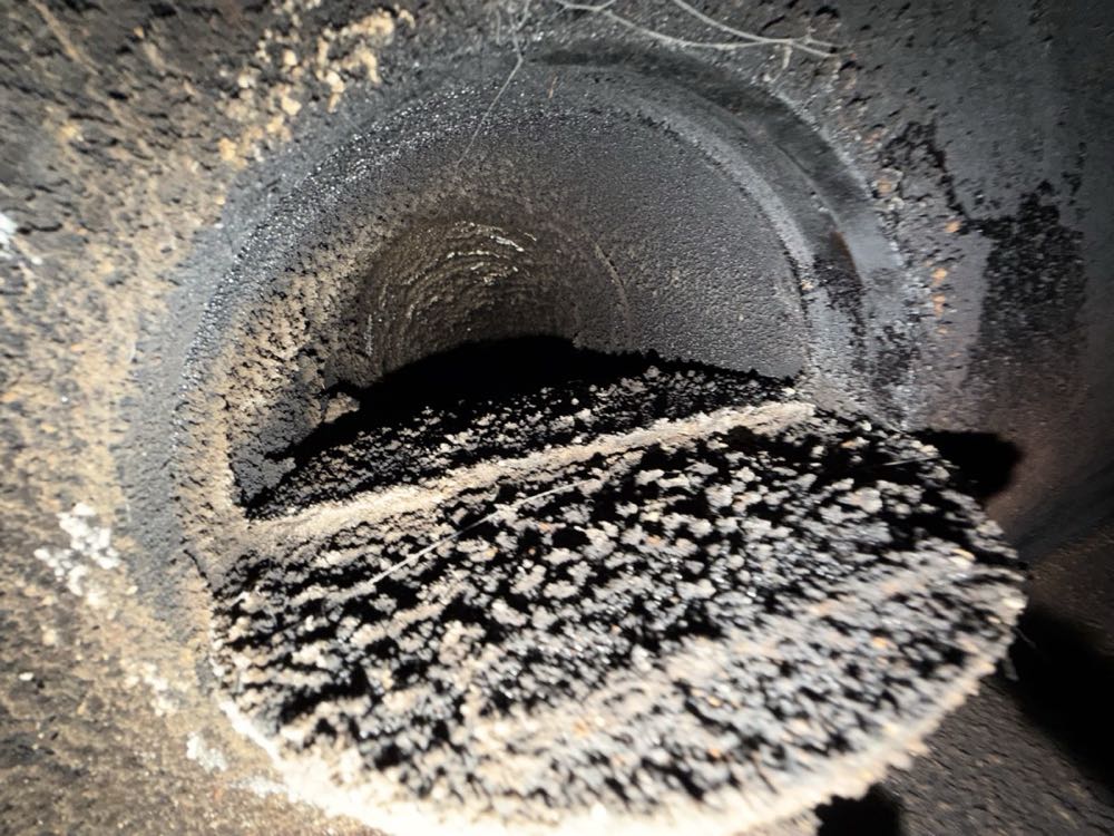 Heat damage and creosote staining above a firebox showing why cracked refractory needs repair