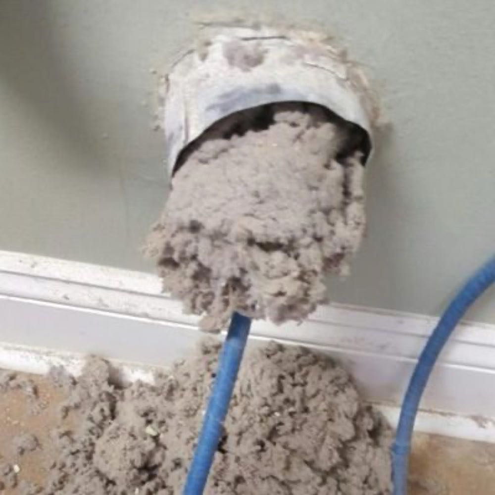 Thick lint being pulled out of a clogged dryer vent duct in a Dallas–Fort Worth home