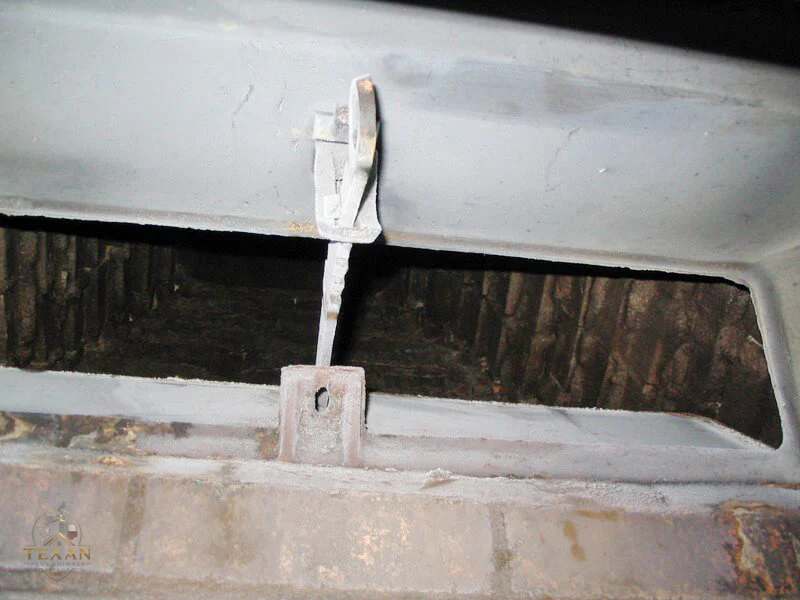 Cast-iron throat damper inside a Dallas fireplace — the hinge and plate we repair or replace