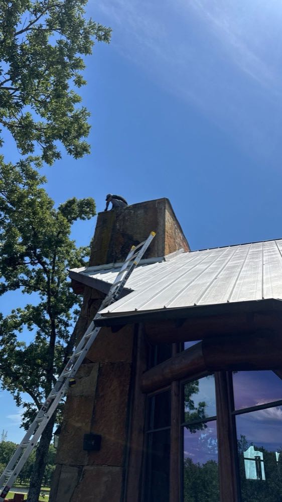 Ladder set against a North Texas chimney during roof flashing repair