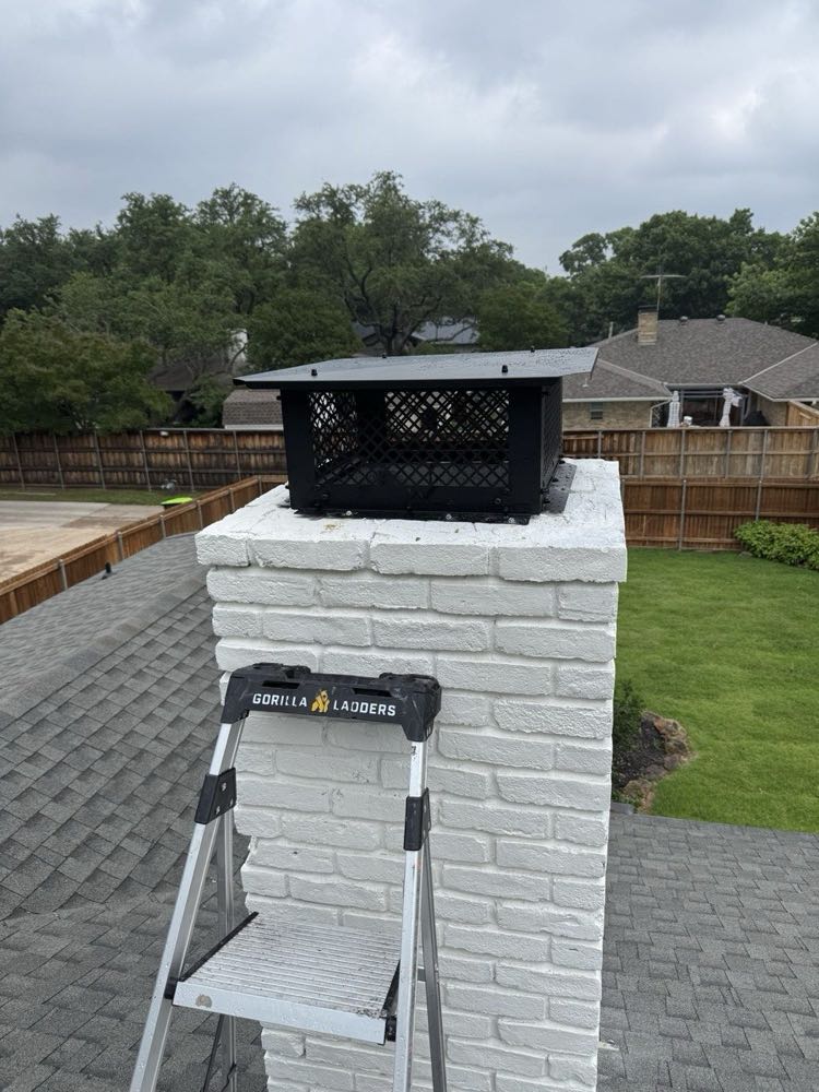 Technician ladder set on a white brick chimney during a Level 2 camera inspection in Dallas